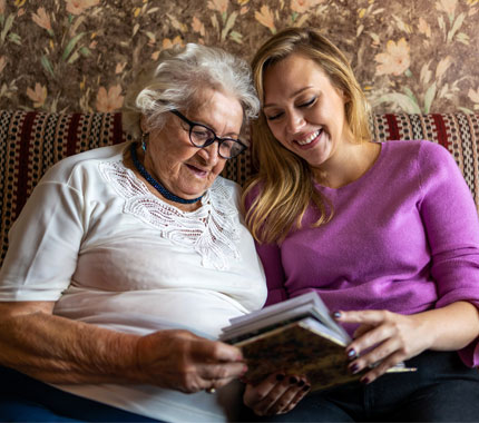 daughter reading to her elderly mother